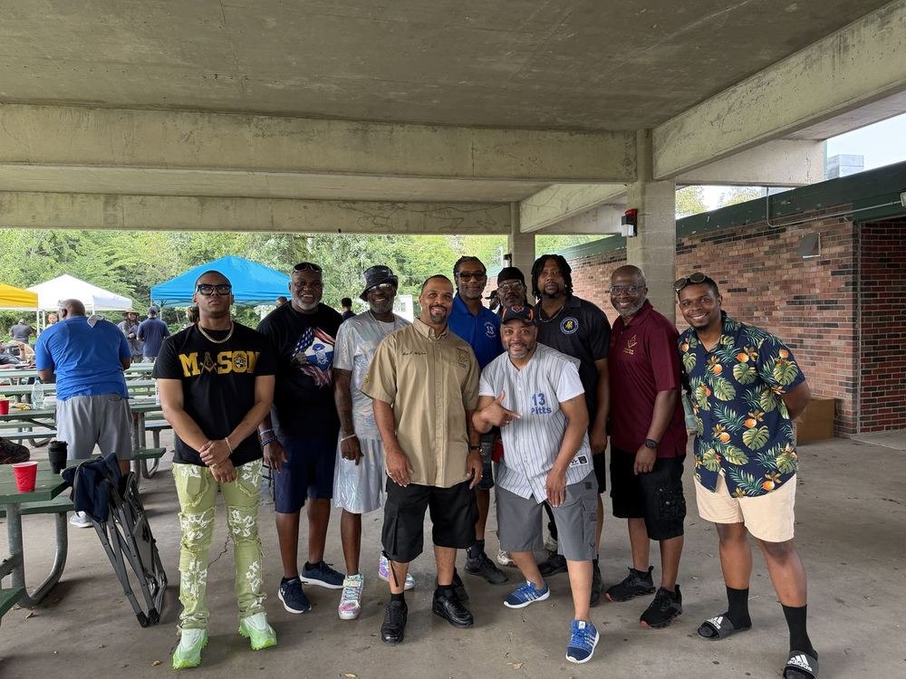 Ten brethren of the lodge gathered together in casual dress under a park pavilion at a lodge cookout.